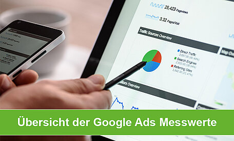 Eine Hand zeigt mit einem schwarzen Stift auf einen Monitor