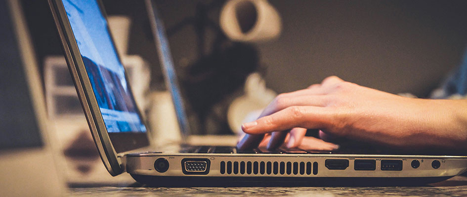 Zwei Hände tippen auf einer Laptop-Tastatur
