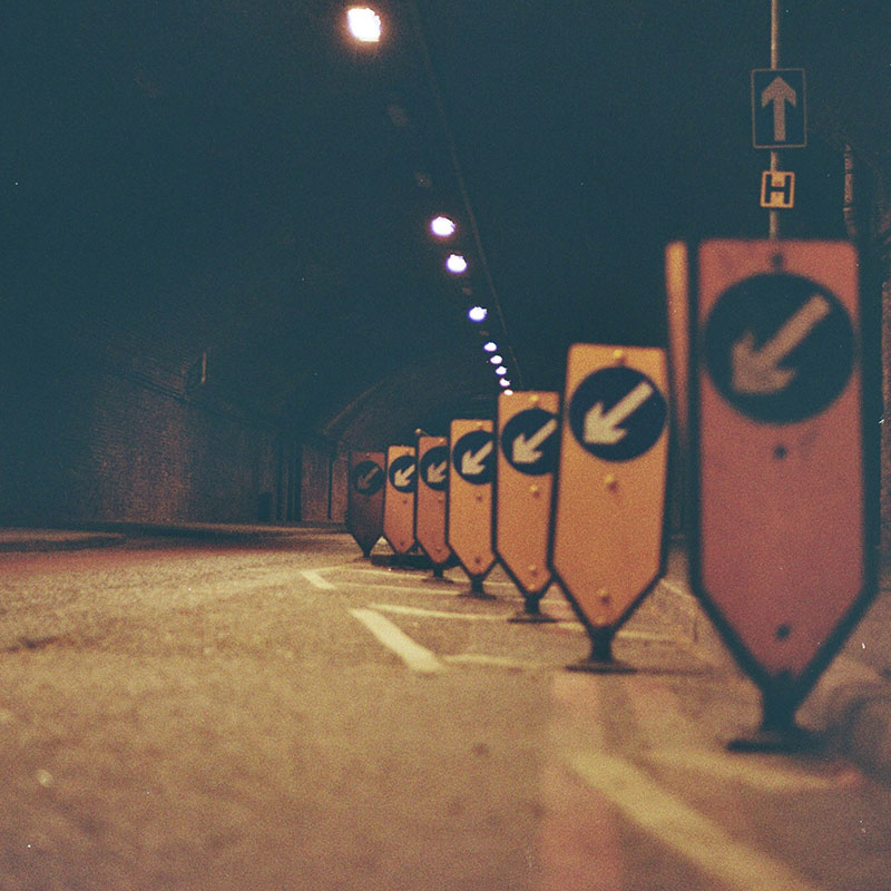 Eine Reihe von Straßenschildern, die am Straßenrand sitzen