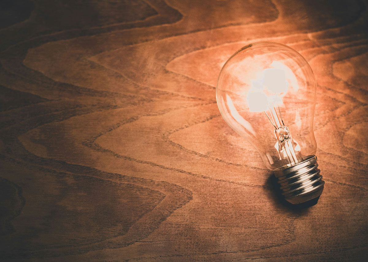 Inbound Marketing Eine leuchtende Glühbirne auf einem Holztisch