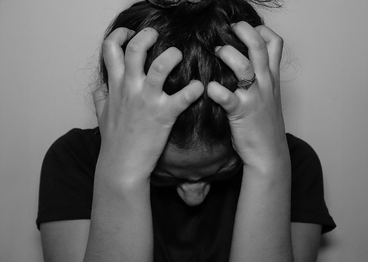 Warum ist Keyword Stuffing problematisch? Dieses Bild zeigt eine Person, die ihre Hände in einer Geste der Anspannung oder Erschöpfung an den Kopf hält.