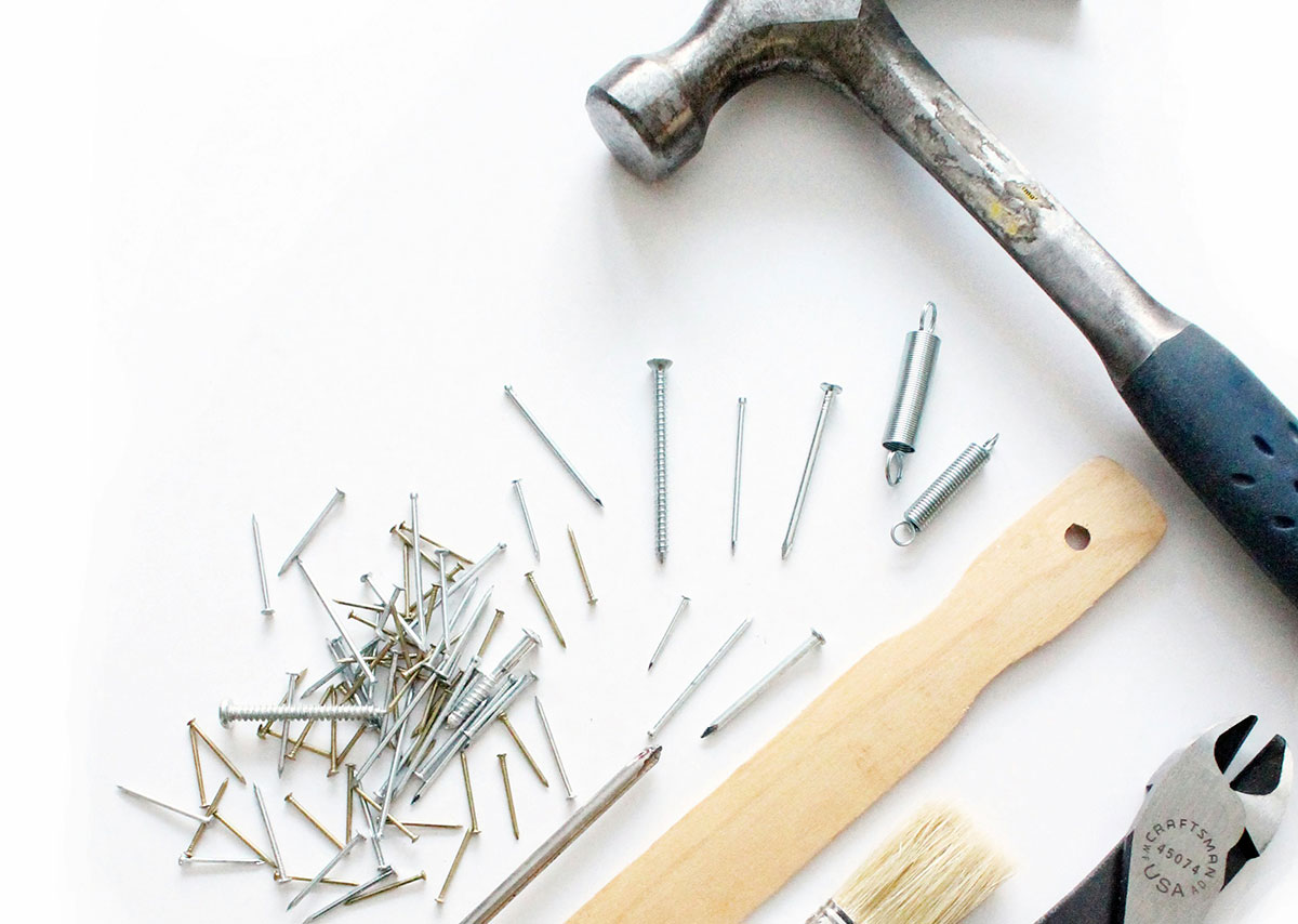 Dieses Bild zeigt eine Auswahl an Werkzeugen und Befestigungsmaterialien, die typischerweise für Reparatur- oder DIY-Projekte verwendet werden.