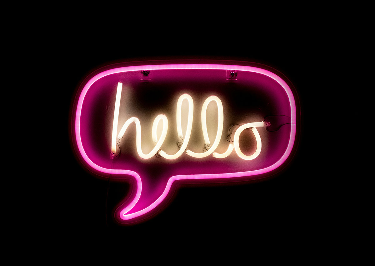 Was ist eine Impression? Ein rosafarbenes Neonschild mit dem warmgelben Schriftzug "hello"