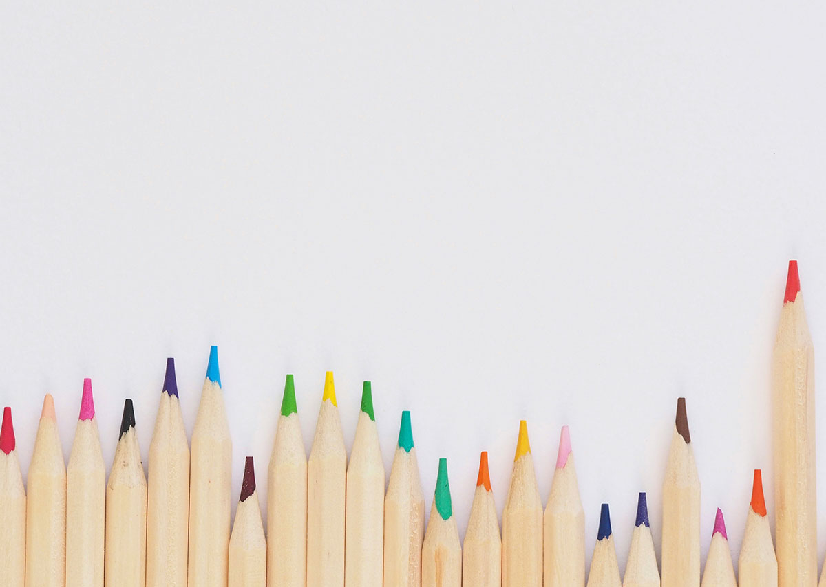 Was sind KPIs? Verschiedene bunte Bleistifte in einer Reihe aufgereiht