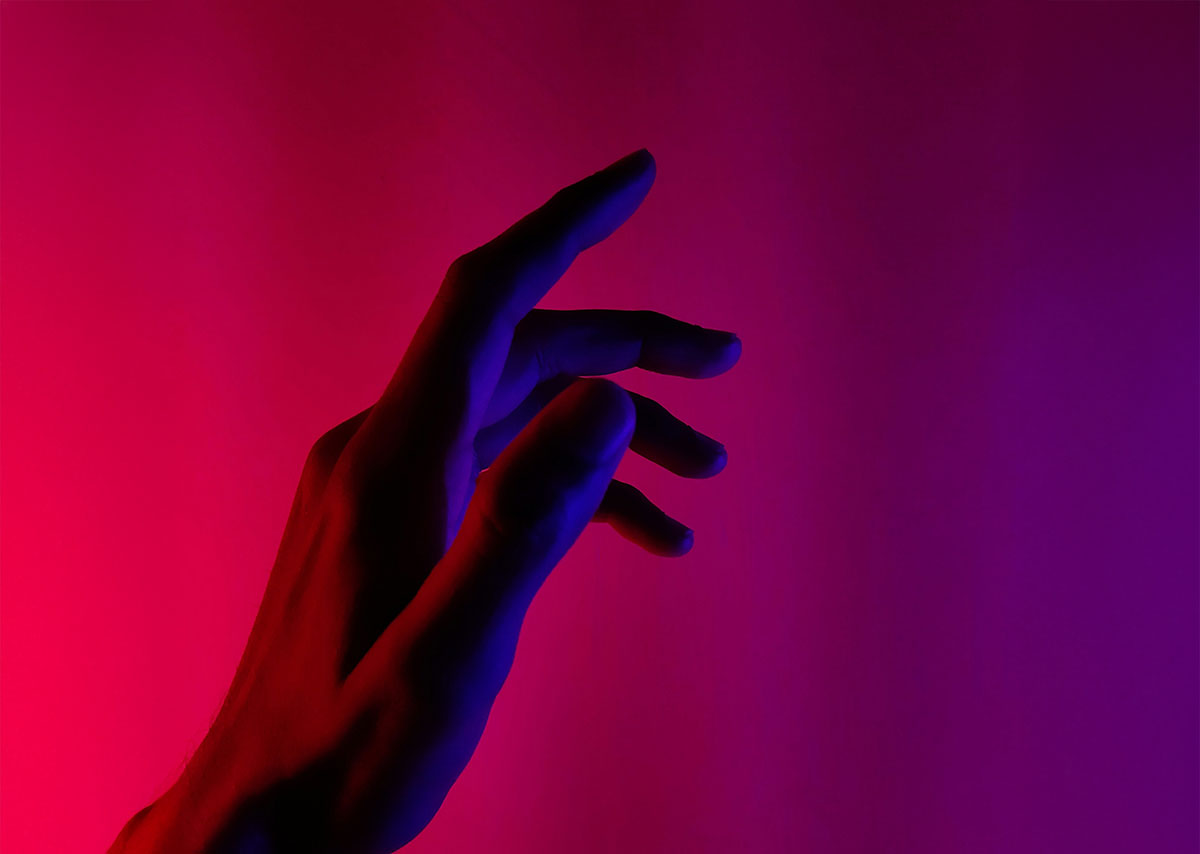 Eine Hand mit ausgestreckten Finger vor einem farbigen Verlauf