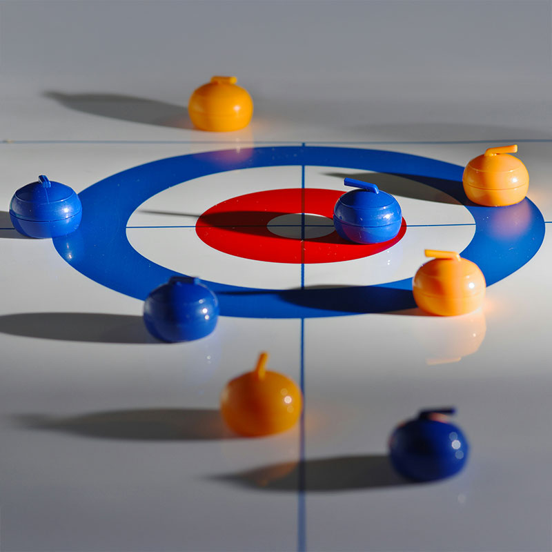 Eine Gruppe von Curlingsteine auf einem Curlingfeld mit rotem und blauem Kreis