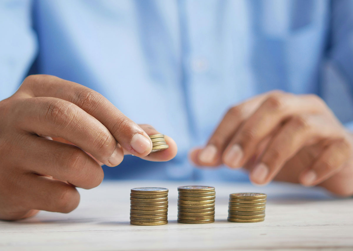 Was sagen Budget Caps aus? Eine Person, die Münzen auf einem Tisch stapelt