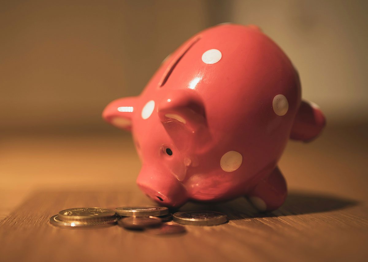 Rosa Schweinemünzbank auf braunem Holztisch