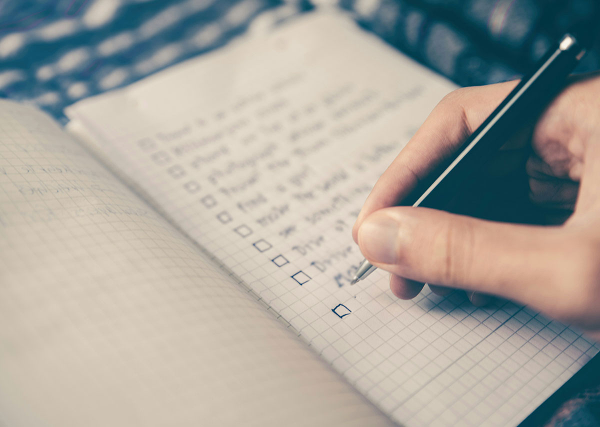 Snippets: Bewährte Vorgehensweise Eine Hand mit Stift hakt eine Checkliste ab