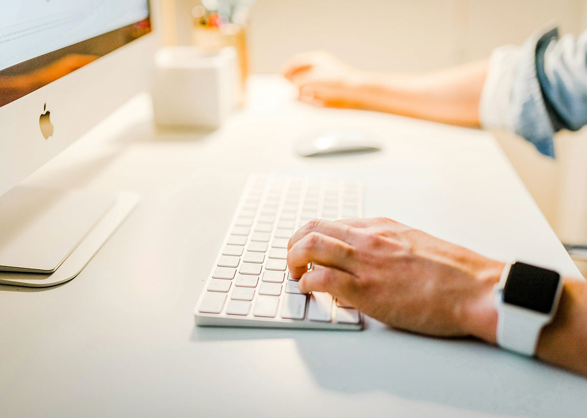 Eine Person benutzt einen iMac mit Tastatur