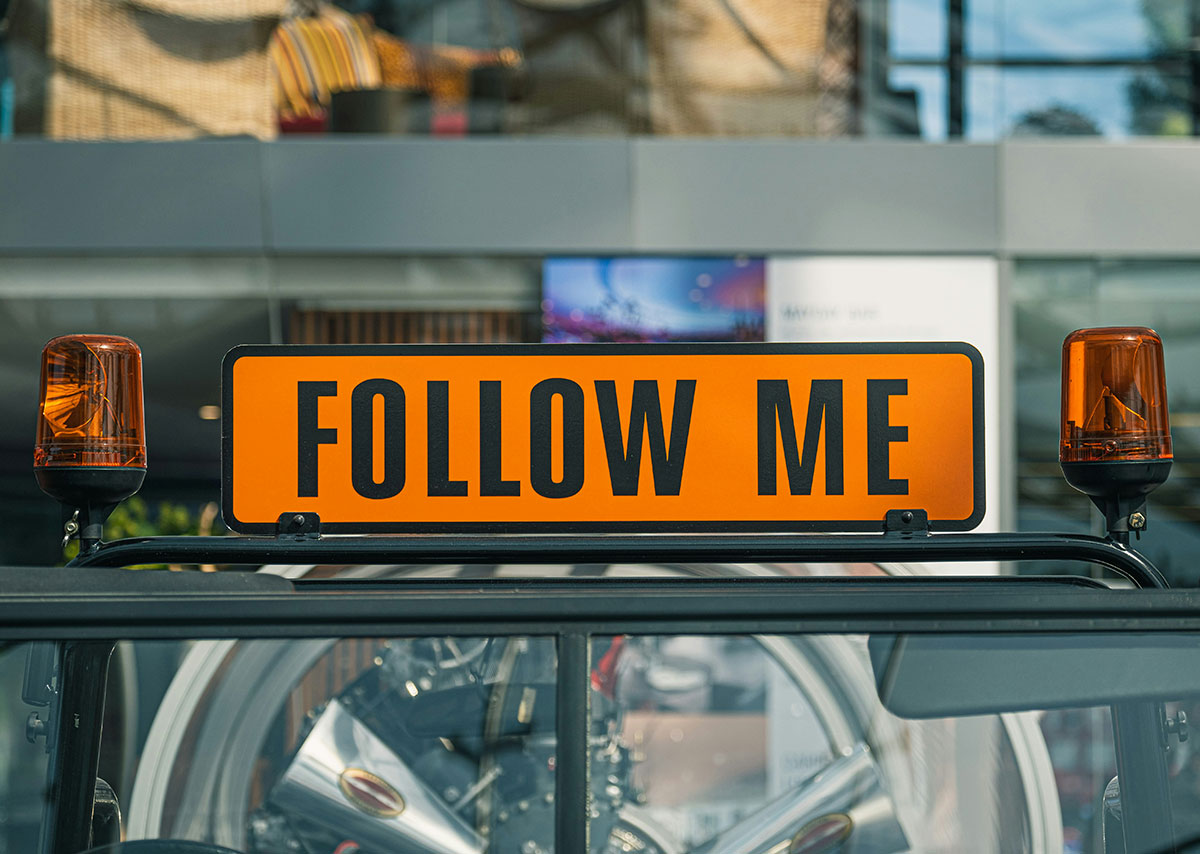 Follower aufbauen Gelb-schwarzes Taxischild mit Follow me darauf