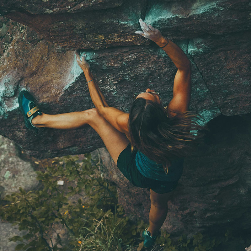 Foto einer Frau, die einen Berg besteigt