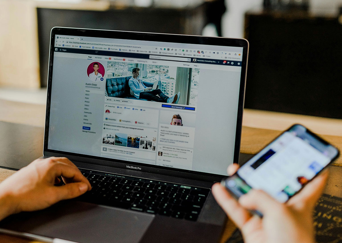 Person, die sowohl Laptop als auch Smartphone verwendet
