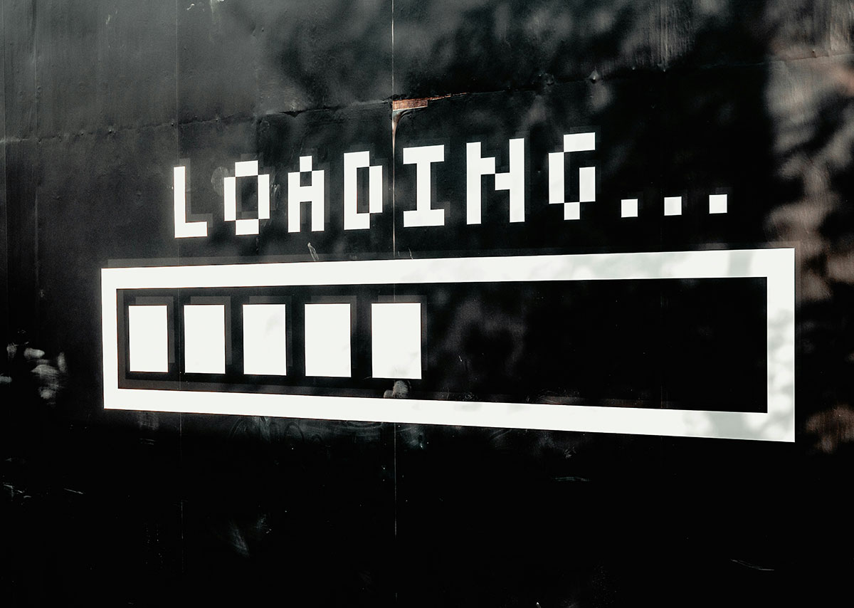 Text Loading mit einem Ladebalken an einer schwarzen Wand